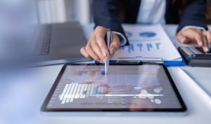 Business professional reviewing IT budget forecasts and financial analytics on a digital dashboard.