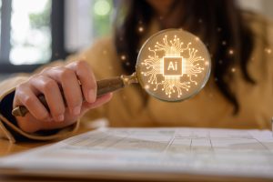 hand holding a magnifying glass with an AI icon, concept of identifying or looking for AI opportunities