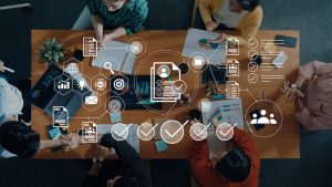 A group of professionals collaborate on technology in a modern office. They engage in strategic discussions, focusing on data analysis.