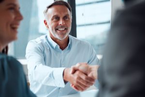 Shot of a locally-owned MPS provider shaking hands with a new customer during a meeting in an office.