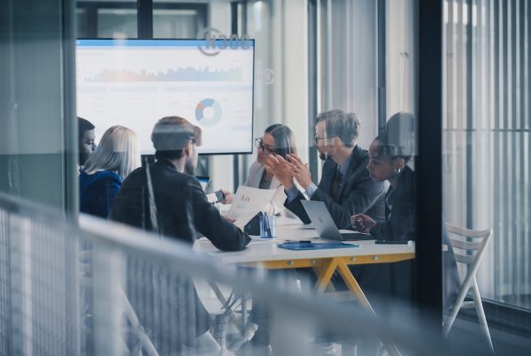 Business leaders reviewing performance charts and reports during a meeting to evaluate technology investments and AI ROI.